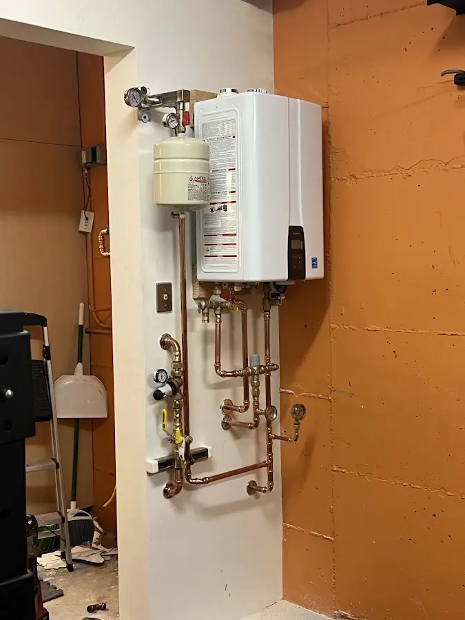 Plumbing technician inspecting water heater connections in Euclid